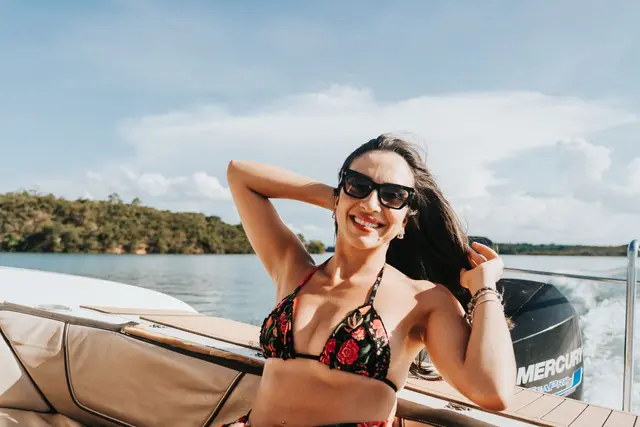 Hóspede sorrindo em passeio de lancha no Lago de Furnas em Capitólio